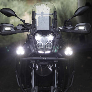 DENALI D3 LED driving lights mounted on a motorcycle front end with bright white spot beams illuminated.