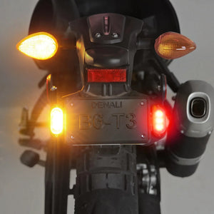 DENALI T3 rear LED signal pods mounted on a motorcycle showing amber turn signals and red brake lighting.