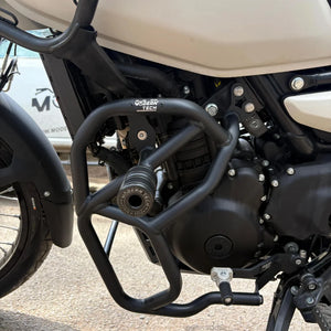 Black tubular steel engine crash guard with slider installed on a Royal Enfield Himalayan 450 motorcycle.