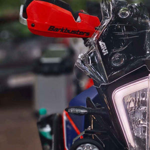 Motodrift Barkbusters two-point mount handguard in bright red installed on a motorcycle handlebar