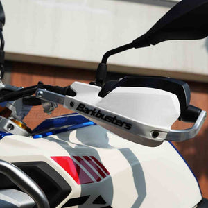 Motodrift Barkbusters two-point mount handguard kit with white plastic guard installed on a motorcycle handlebar