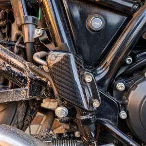 Carbon fiber heel guard installed on a Royal Enfield Interceptor 650 motorcycle frame.