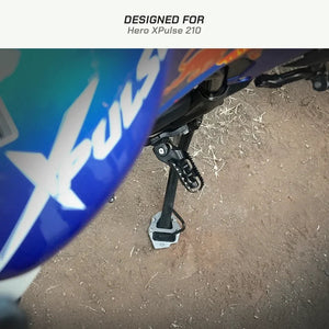 ViaTerra stainless steel side stand shoe installed on a Hero XPulse 210 motorcycle on dirt ground.