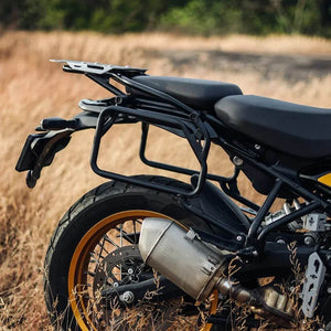 Motorcycle with black seat and luggage rack in a field