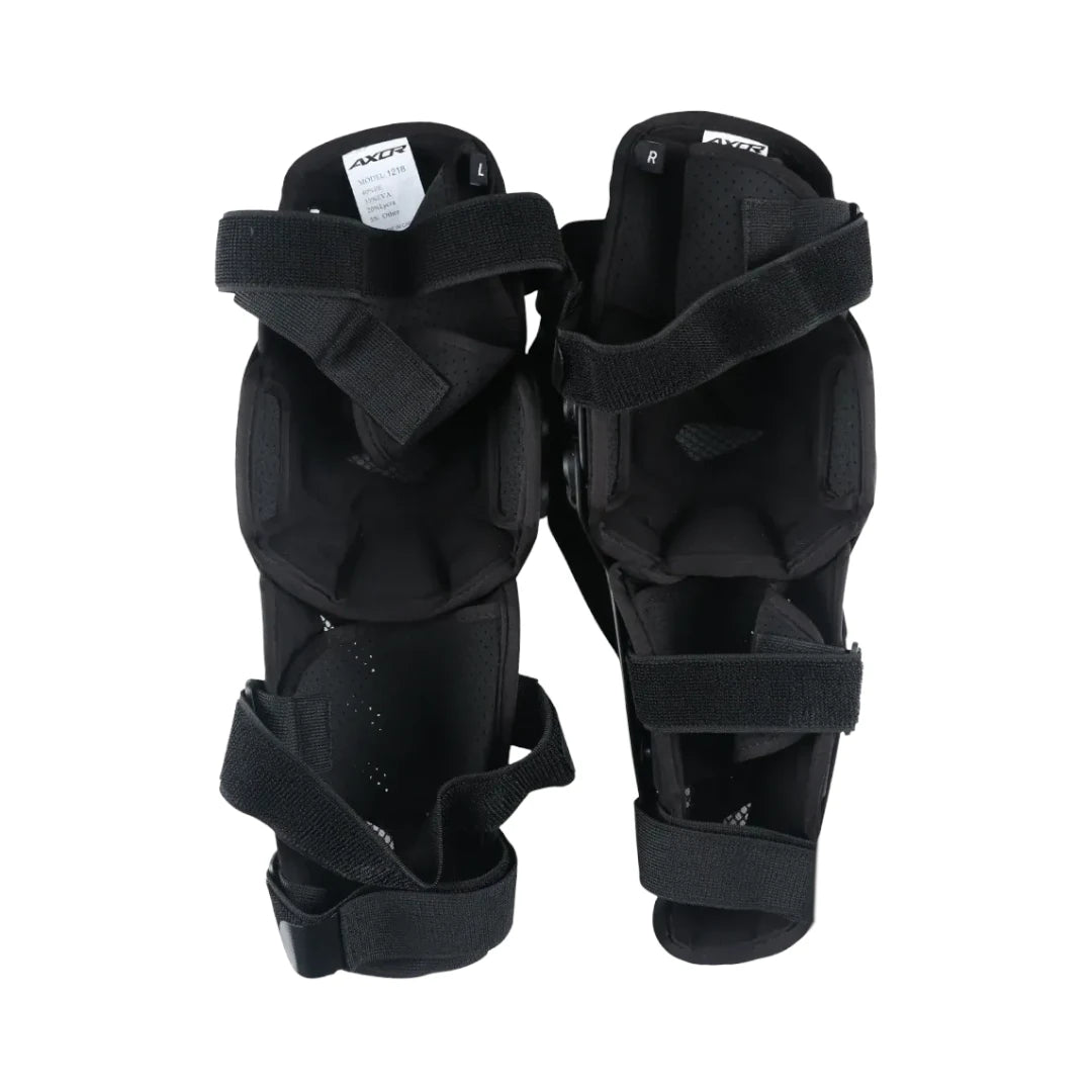 AXOR Impact-X black knee guards with dual-axis bionic design, hard shell sliders, and adjustable straps.