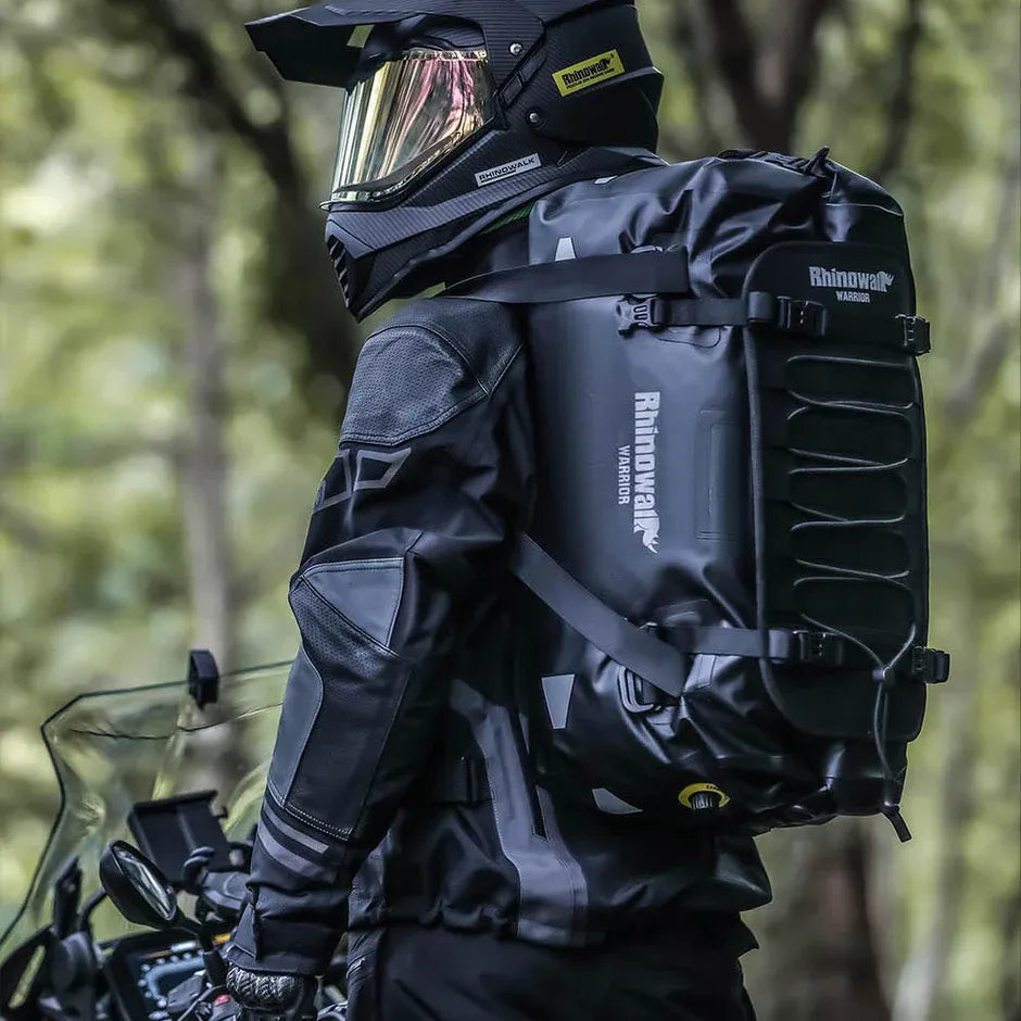 Motodrift Rhinowalk Warrior waterproof motorcycle duffel bag worn by a rider in gear on a bike in a forest setting