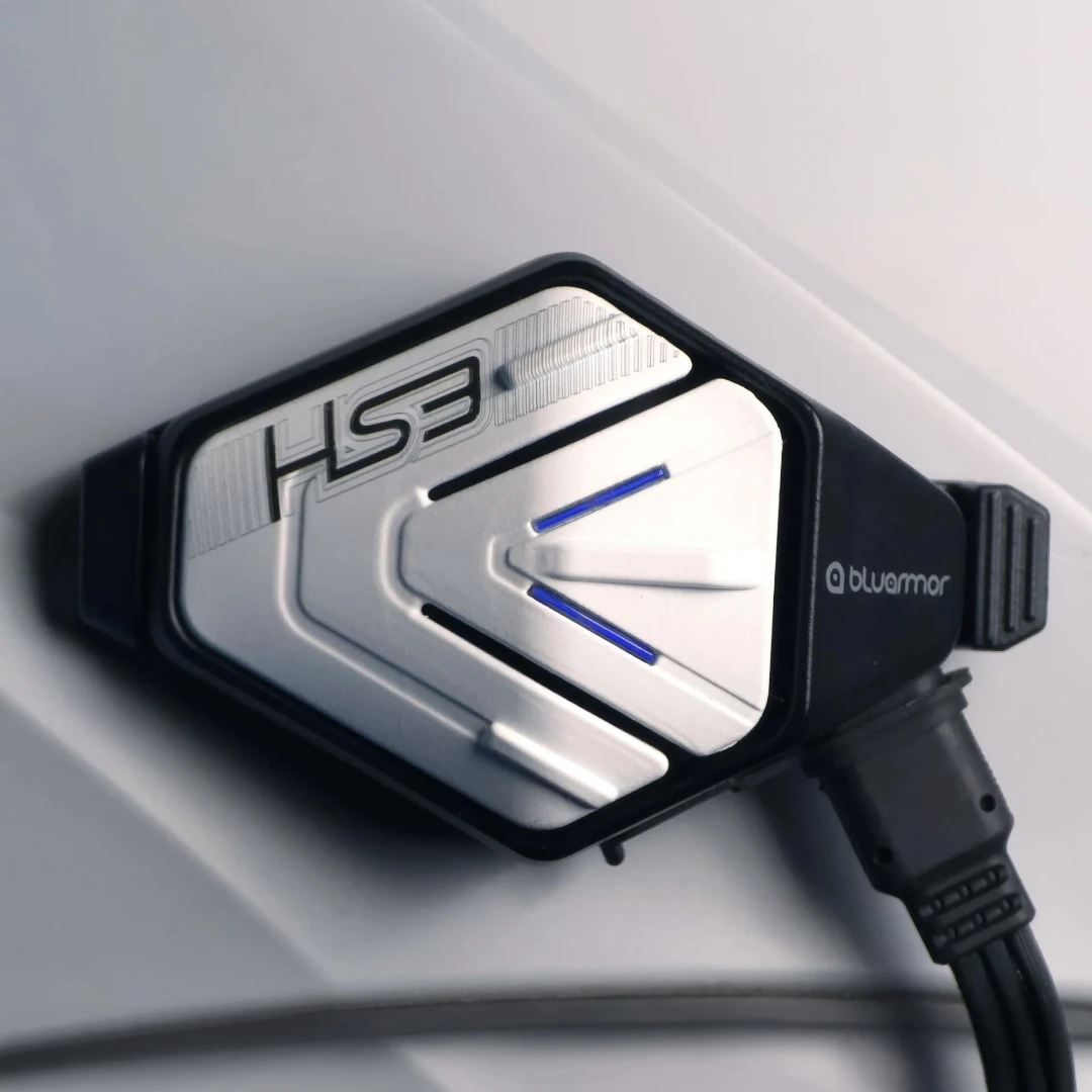 BluArmor HS3 helmet Bluetooth device with silver and black finish mounted on a white helmet surface