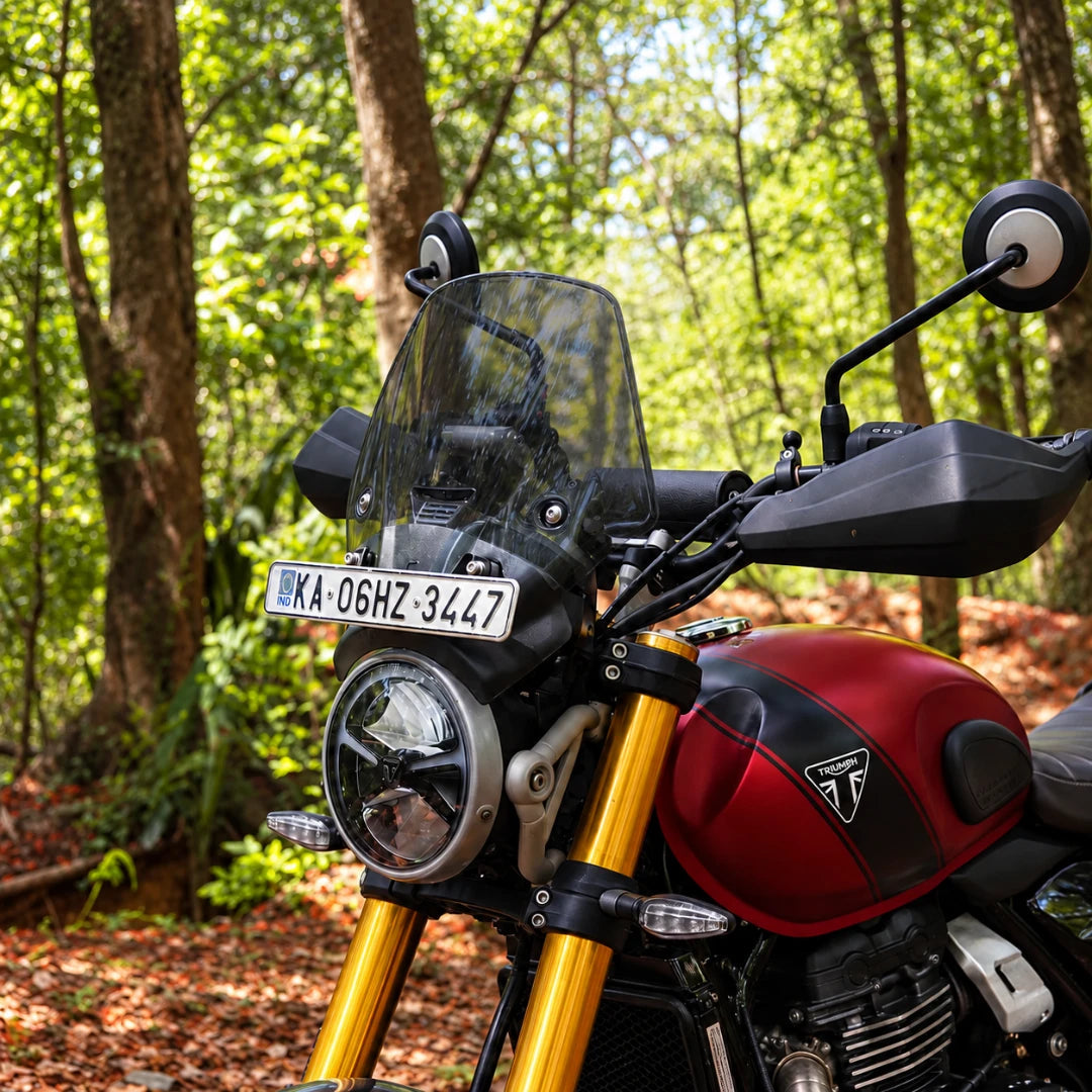 BOLT smoked polycarbonate windscreen installed on a red Triumph Scrambler 400X with GPS mount and number plate