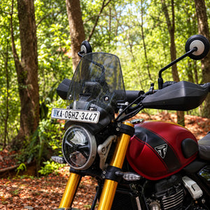 BOLT smoked polycarbonate windscreen installed on a red Triumph Scrambler 400X with GPS mount and number plate
