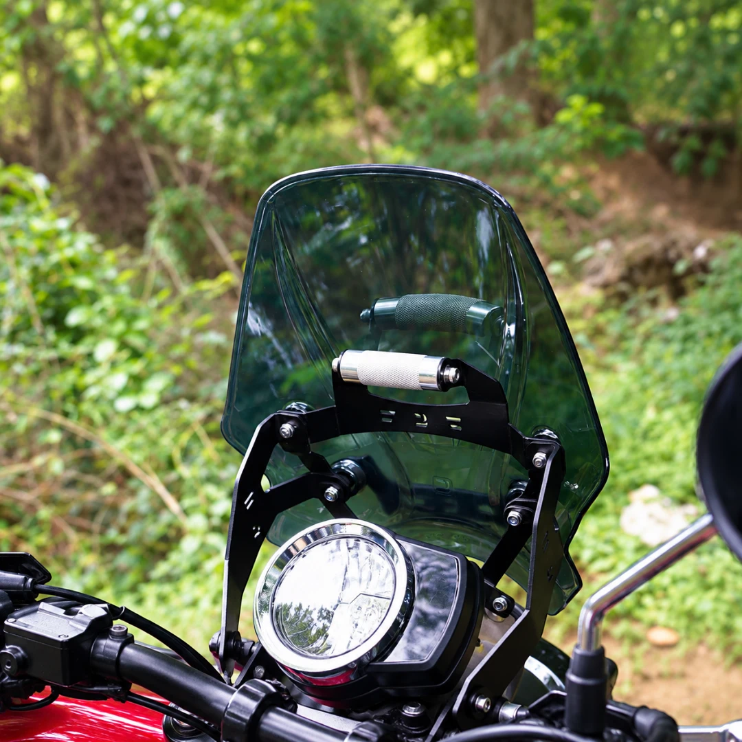 Motodrift smoked BOLT windscreen with GPS mount installed on a Honda CB 350 RS motorcycle in a wooded setting