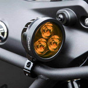DENALI D3 LED motorcycle driving light with amber lens mounted on a black metal crash bar.