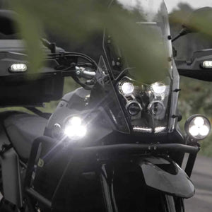 DENALI D3 LED driving lights mounted on a motorcycle front end, showing bright spot beam illumination.