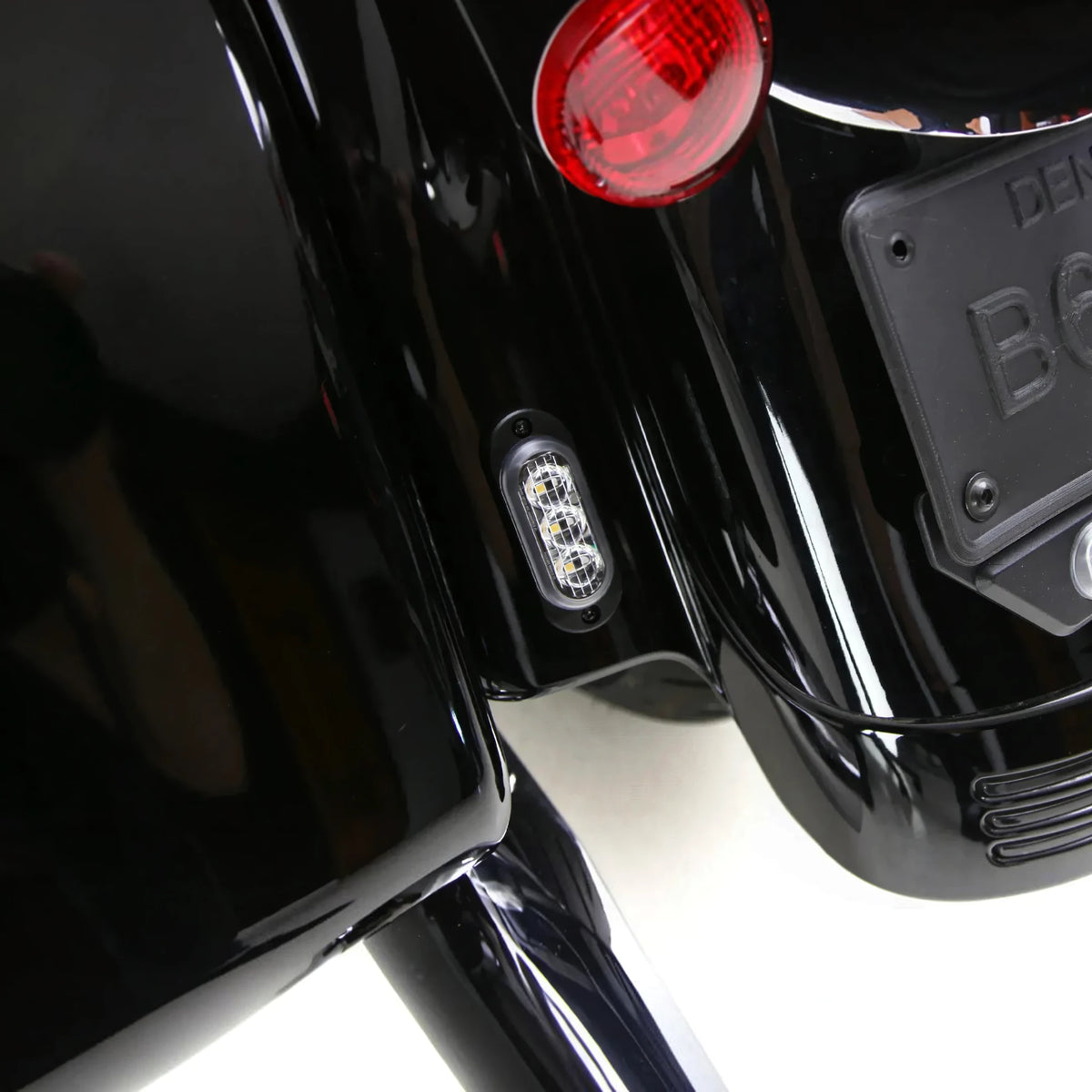 DENALI T3 modular LED rear turn signal pod mounted on a motorcycle fender with red and amber lighting.