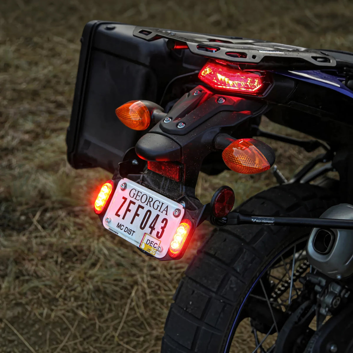 DENALI T3 modular LED rear signal pods mounted on a motorcycle license plate frame with red and amber lights.