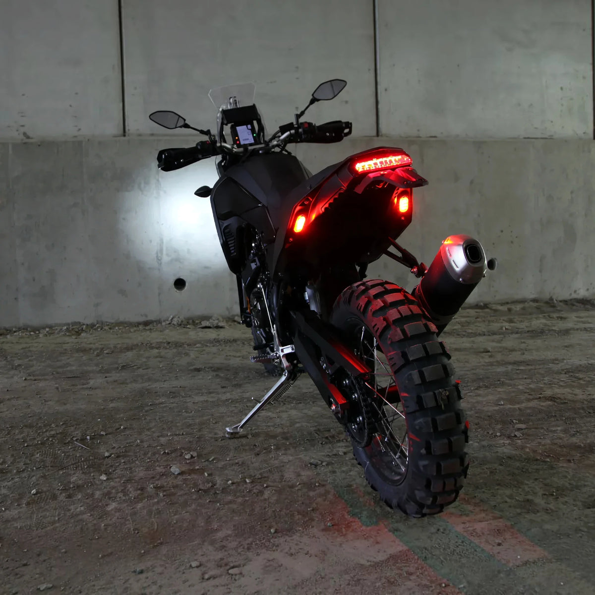 DENALI T3 modular LED rear signal pods glowing red on a motorcycle fender for enhanced visibility.