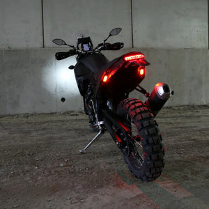 DENALI T3 modular LED rear signal pods glowing red on a motorcycle fender for enhanced visibility.