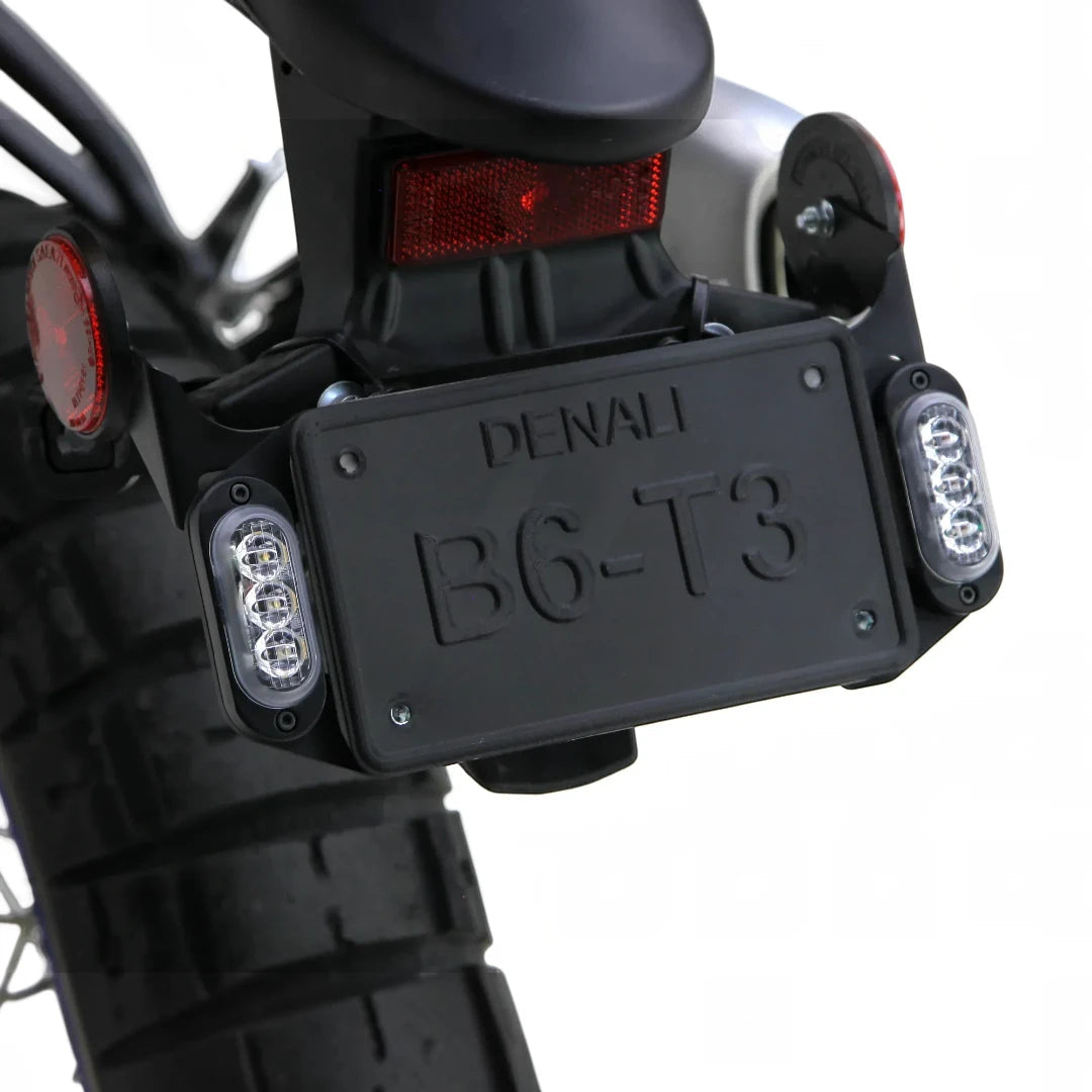 Denali T3 license plate mount with black steel brackets holding rear signal pods on a motorcycle