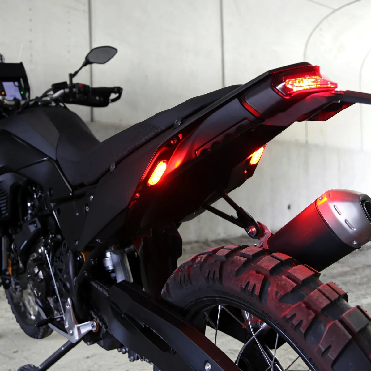 DENALI T3 modular LED rear turn signal pods with red running and brake lights installed on a motorcycle.