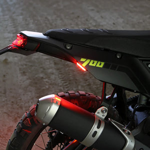 DENALI T3 modular LED rear signal pod mounted on a motorcycle fender with red running light illumination.