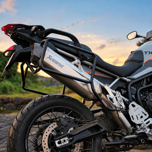 Legundary Fort Knox side box mount installed on a Triumph Tiger 900 motorcycle with an Akrapovic exhaust.