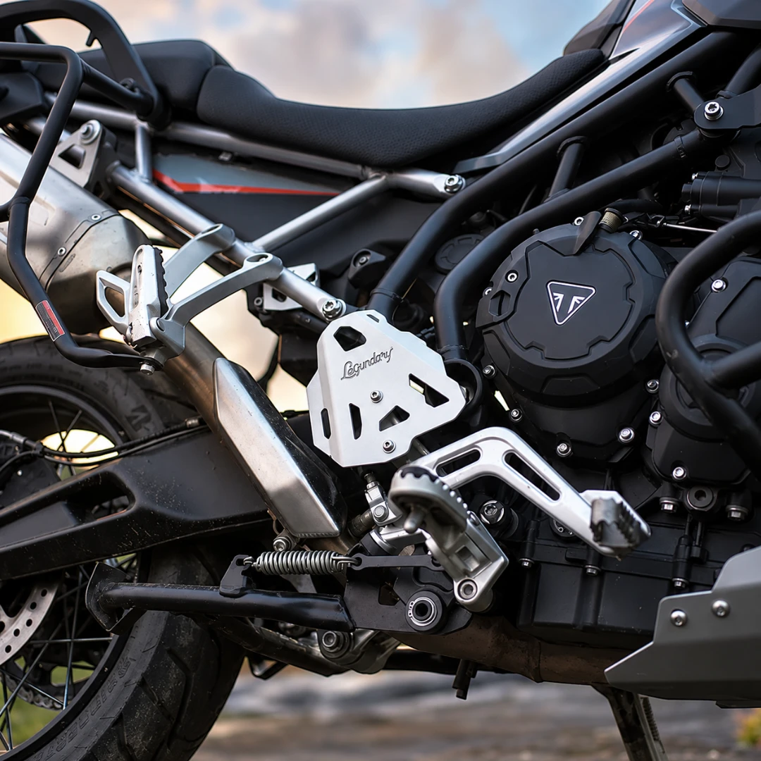 Silver aluminium Legundary Titan boot guards installed on a Triumph Tiger 900 motorcycle frame