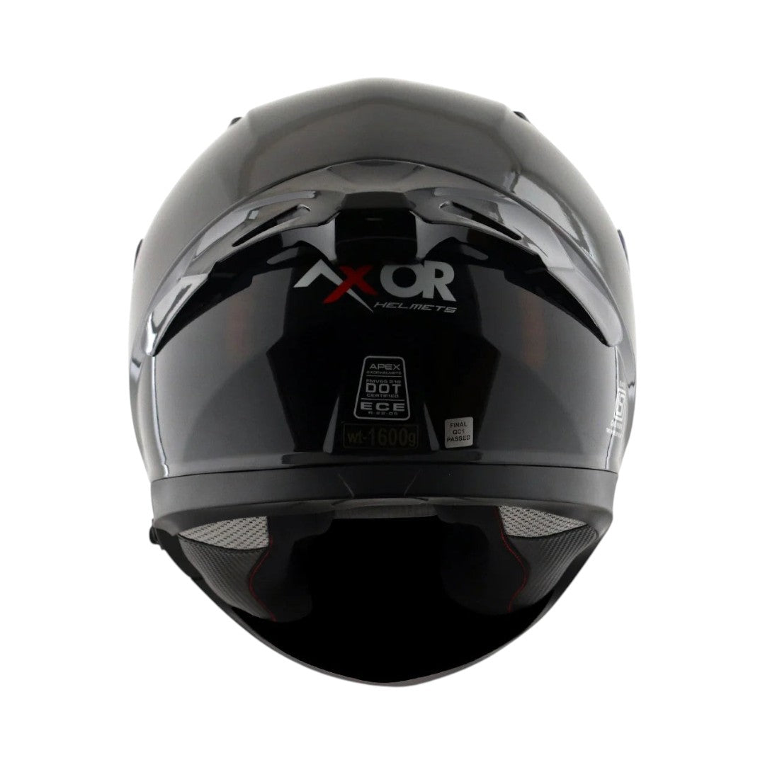 Motodrift Axor Apex Solid full-face motorcycle helmet in glossy black, rear view showing certification labels.