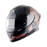 Motodrift Axor Apex Trance full-face helmet in black with intricate orange and blue sun and skull graphic designs.