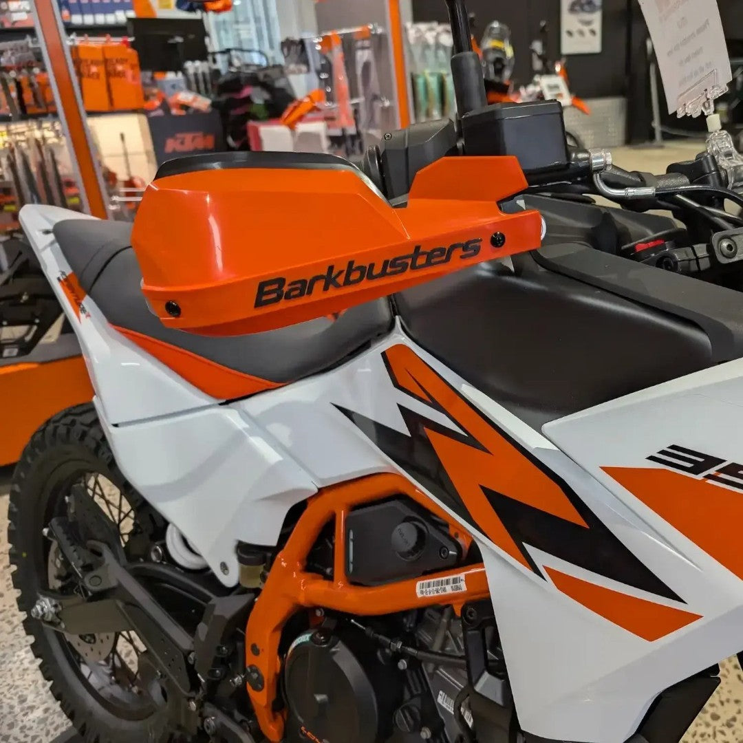 Motodrift Barkbusters handguard kit with orange plastic guards installed on a white and orange KTM 390 Adventure