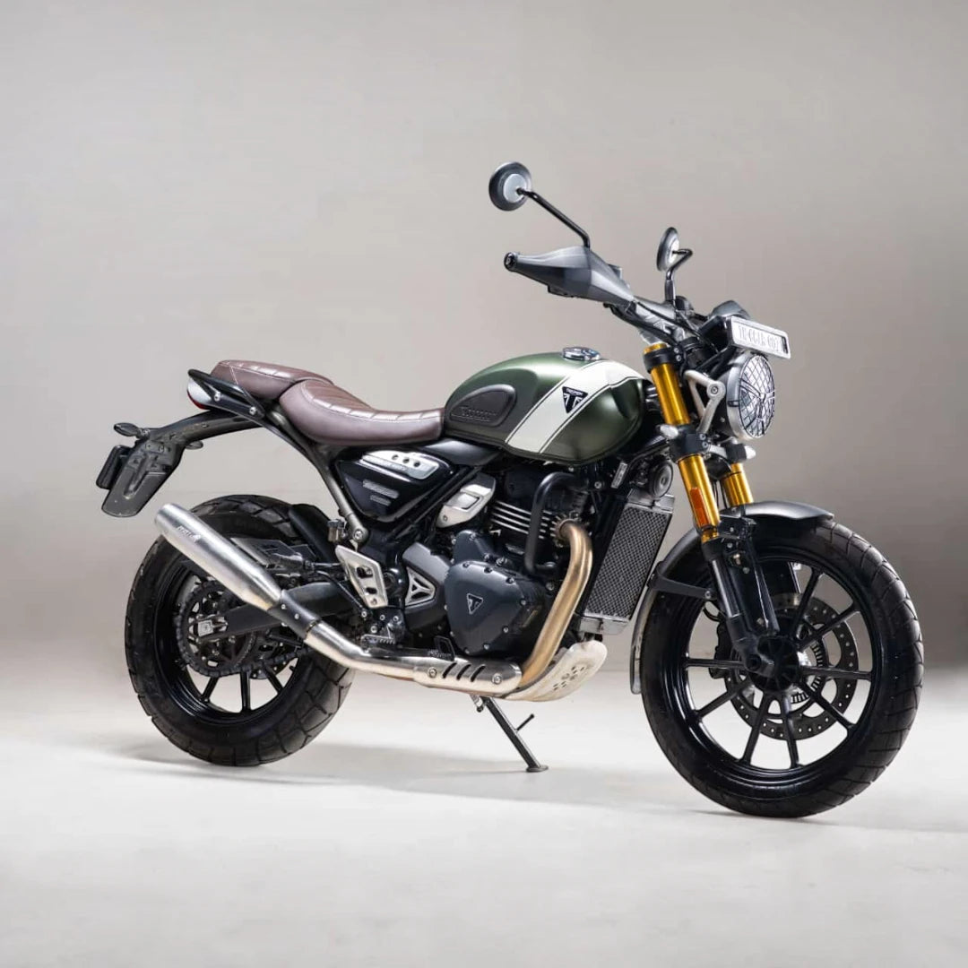 Motodrift silver Blaze performance exhaust installed on a green Triumph Scrambler 400X motorcycle