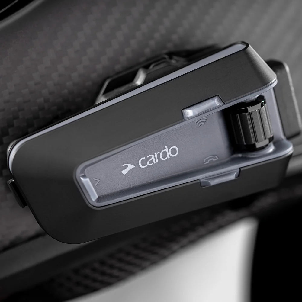 Motodrift Cardo Packtalk Neo motorcycle helmet intercom mounted on a helmet, featuring a sleek black design.