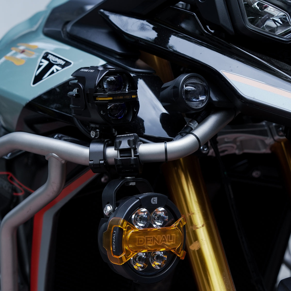 Motodrift Denali D7 PRO auxiliary light pod with amber X-Lens mounted on a motorcycle crash bar