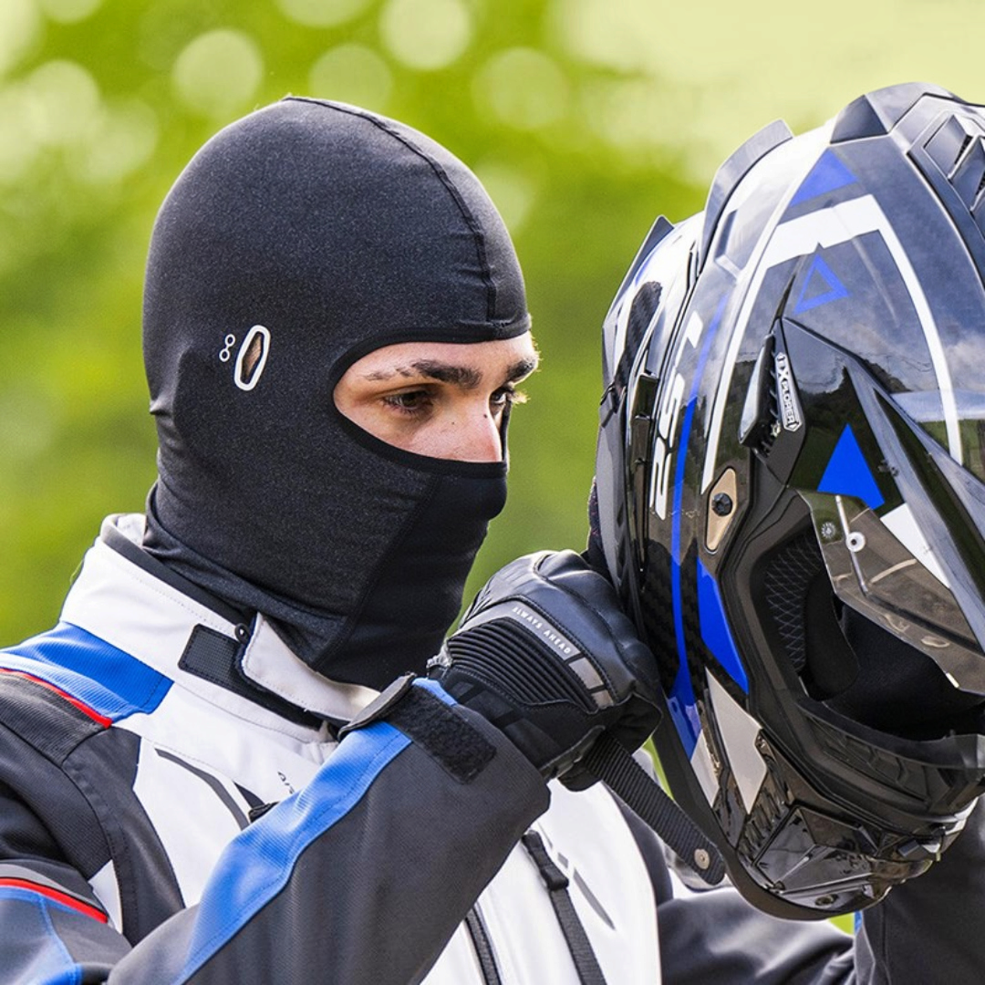 Motodrift LS2 black lycra balaclava worn by a rider putting on a motorcycle helmet for wind and dust protection