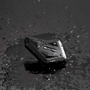 Motodrift MIDLAND BT MINI motorcycle intercom unit in black, shown in a rainy setting to highlight water resistance.