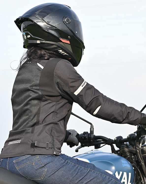 Motodrift ViaTerra Ellis women's black motorcycle riding jacket with reflective details worn by a rider on a bike