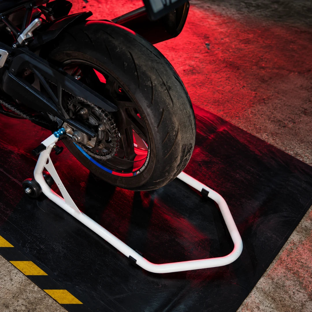 RKTECH white universal motorcycle paddock stand supporting a bike rear wheel for maintenance