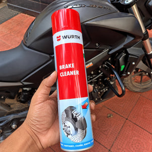 Wurth 700ml brake cleaner and degreaser spray can held in hand in front of a motorcycle